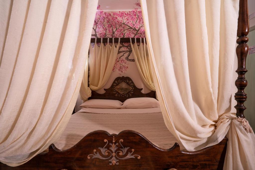 un letto a baldacchino con tende sopra di Villa D'Anzi B&B a Ginosa