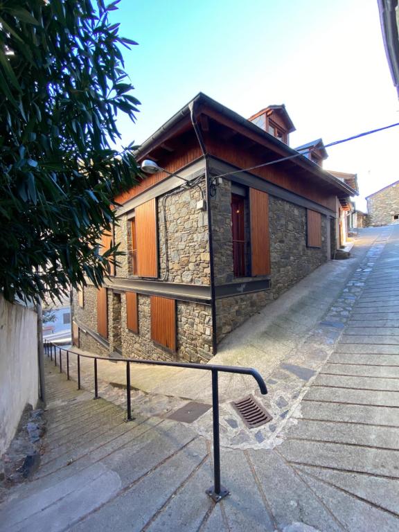 ein kleines Gebäude mit Geländer neben einer Straße in der Unterkunft CAL DOMÈNEC - Dúplex lujo en Rialp ( Se admiten mascotas) in Rialp