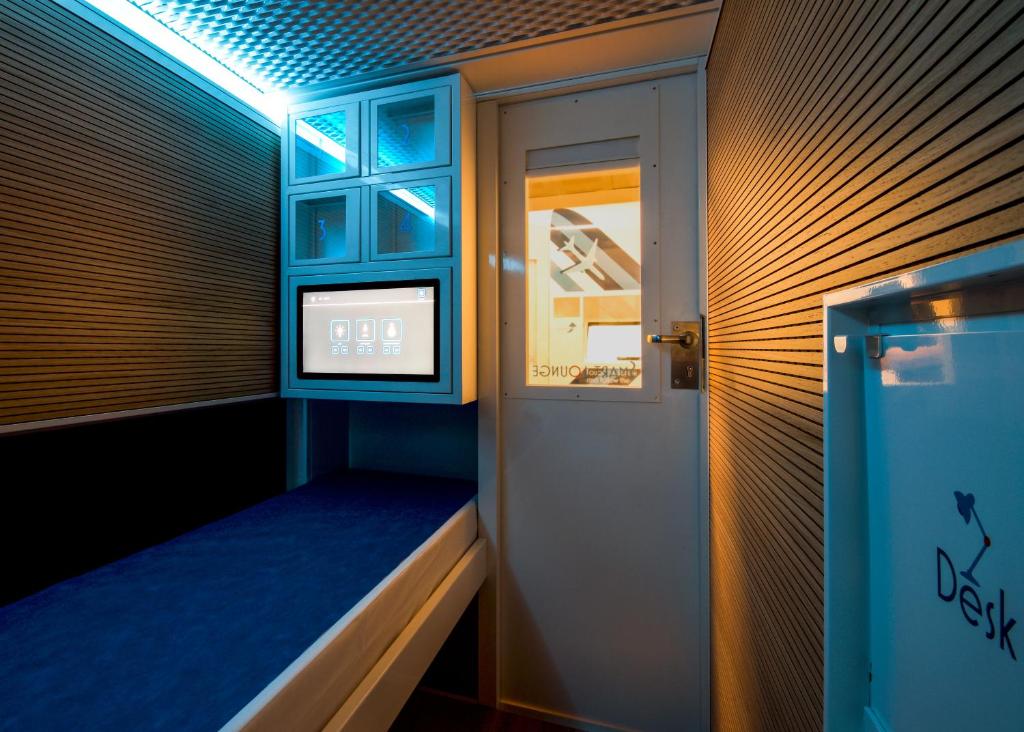 een kamer met een raam en een klok aan de muur bij Resting Pods - Zzzleepandgo Wien Airport in Schwechat