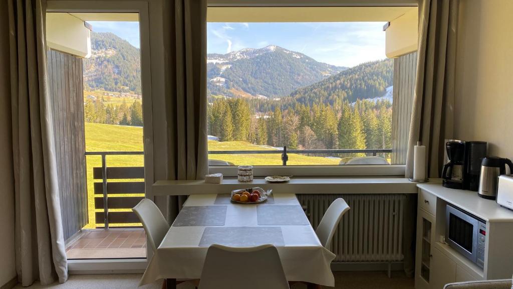 a table and chairs in a room with a large window at Sofia in Balderschwang
