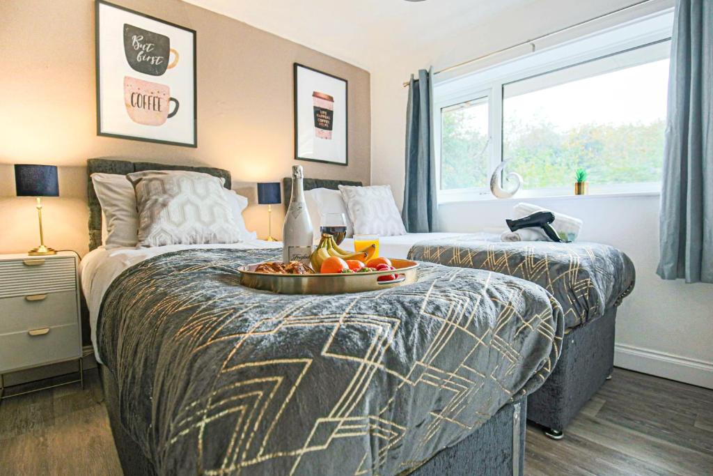 1 dormitorio con 2 camas y bandeja de fruta en la cama en Hornbeam House with Free Parking, Super-Fast WIFI and Smart TV by Yoko Property, en Milton Keynes