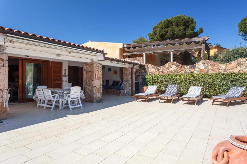 Un patio con sillas y una mesa y una valla. en Casa Isabella villa con dependance, en Porto San Paolo
