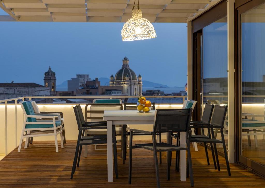 einen Tisch und Stühle auf einem Balkon mit Aussicht in der Unterkunft Attico Terrammare in Trapani