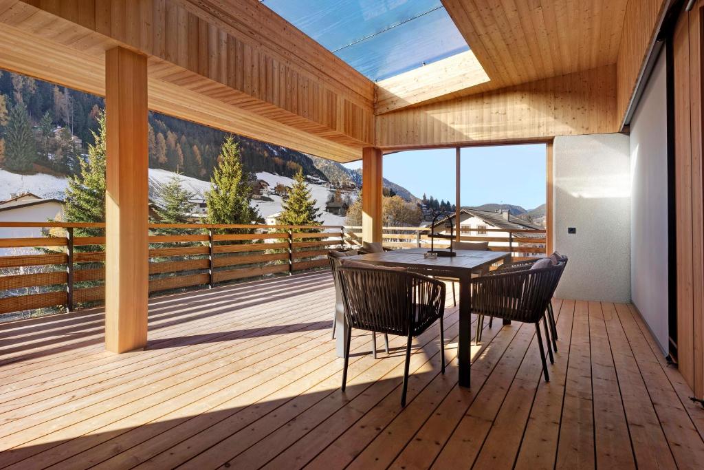 a room with a table and chairs on a deck at Noreia Granda in Ortisei