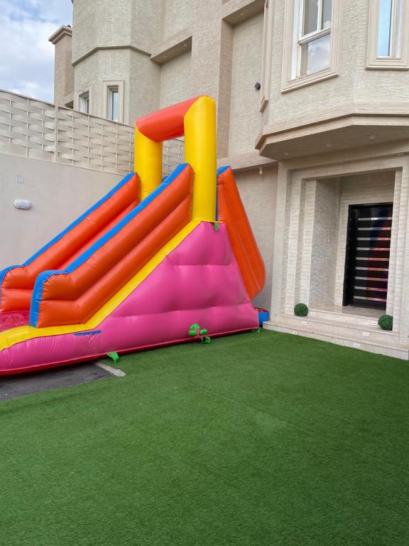 a playground with a slide on a lawn at شاليهات اليخت بالبشائر in Al Qārah