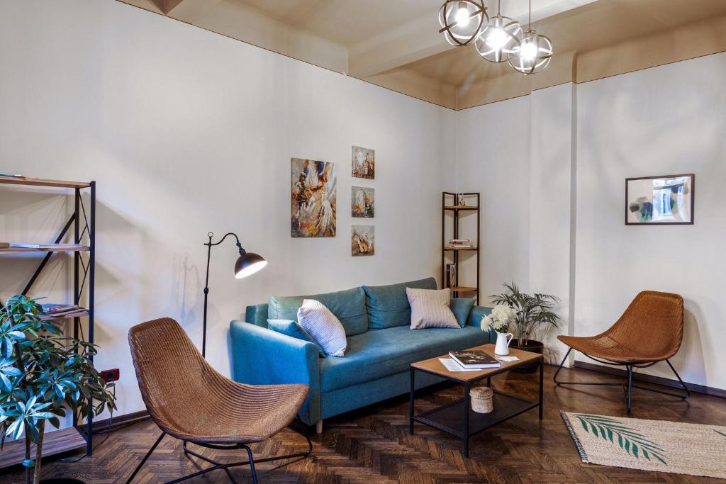 sala de estar con sofá azul y sillas en Sweet Dreams Suites Piata Romana en Bucarest