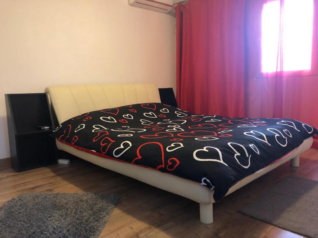 een bed met een zwart-wit dekbed en een raam bij Jane House 2 in Boekarest