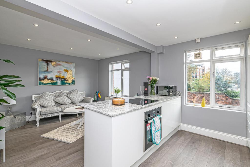 チェスターにあるThe POPULAR Chester Racecourse Apartments, Sleeps 4, FREE Parkingのキッチン(カウンター付)、リビングルーム(ソファ付)