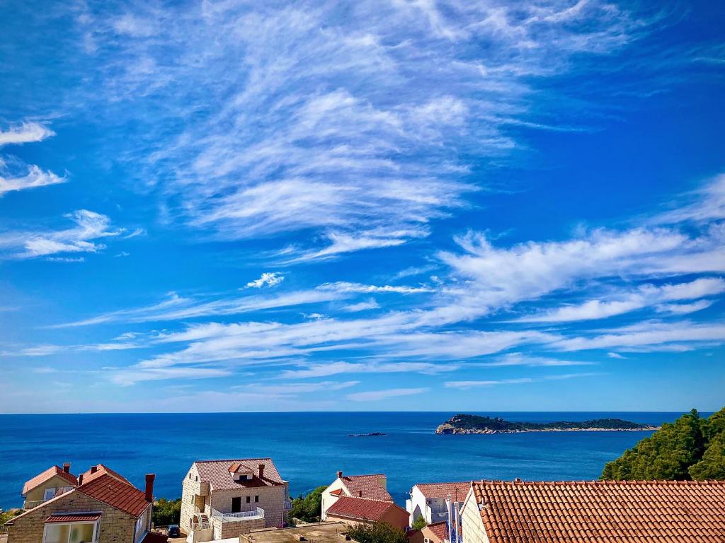 a view of the ocean with houses and a blue sky at Indigo Cavtat Apartments in Cavtat