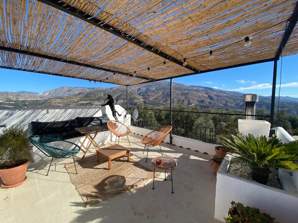 een patio met stoelen en uitzicht op de bergen bij Casa Limon in Pinos del Valle