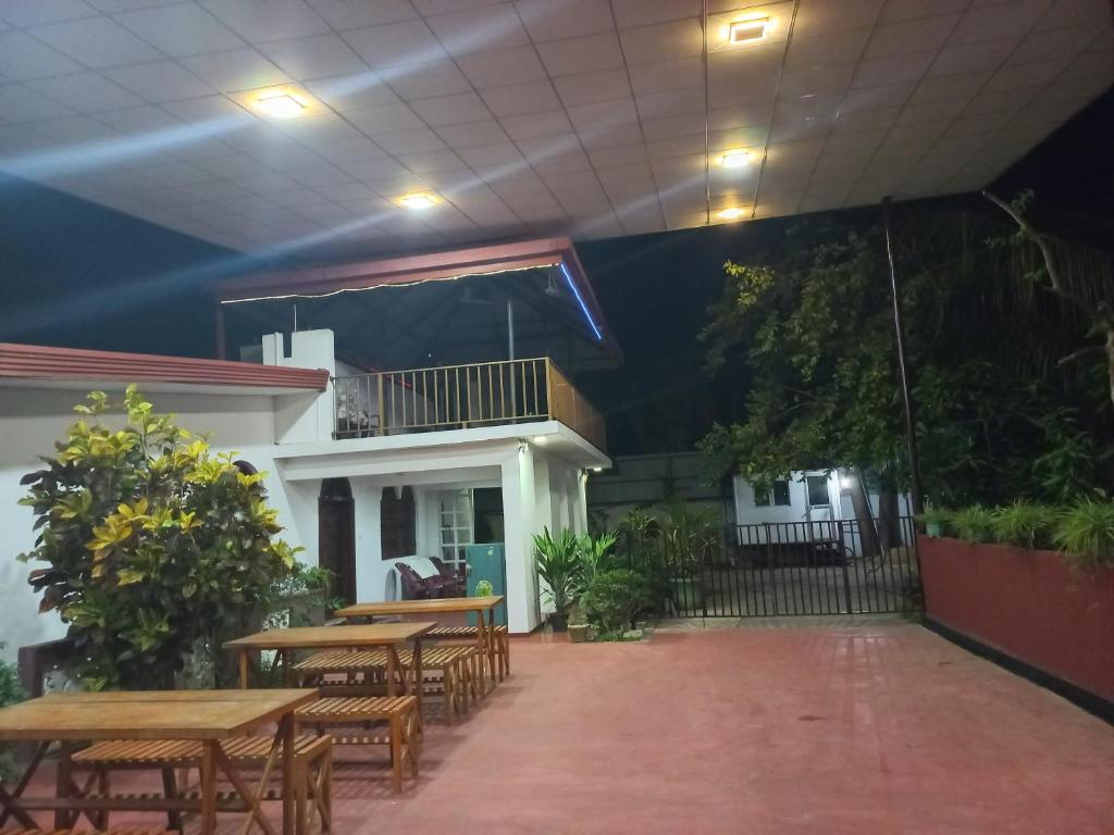 a patio with tables and chairs and a balcony at Mayura Rest Inn in Tissamaharama