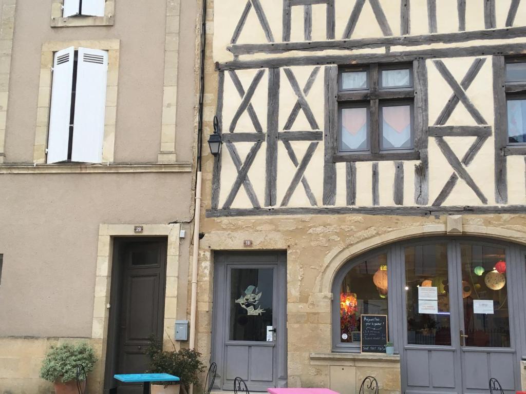 un edificio antiguo con una ventana y una tienda en Gîte Orget, en Saint-Macaire