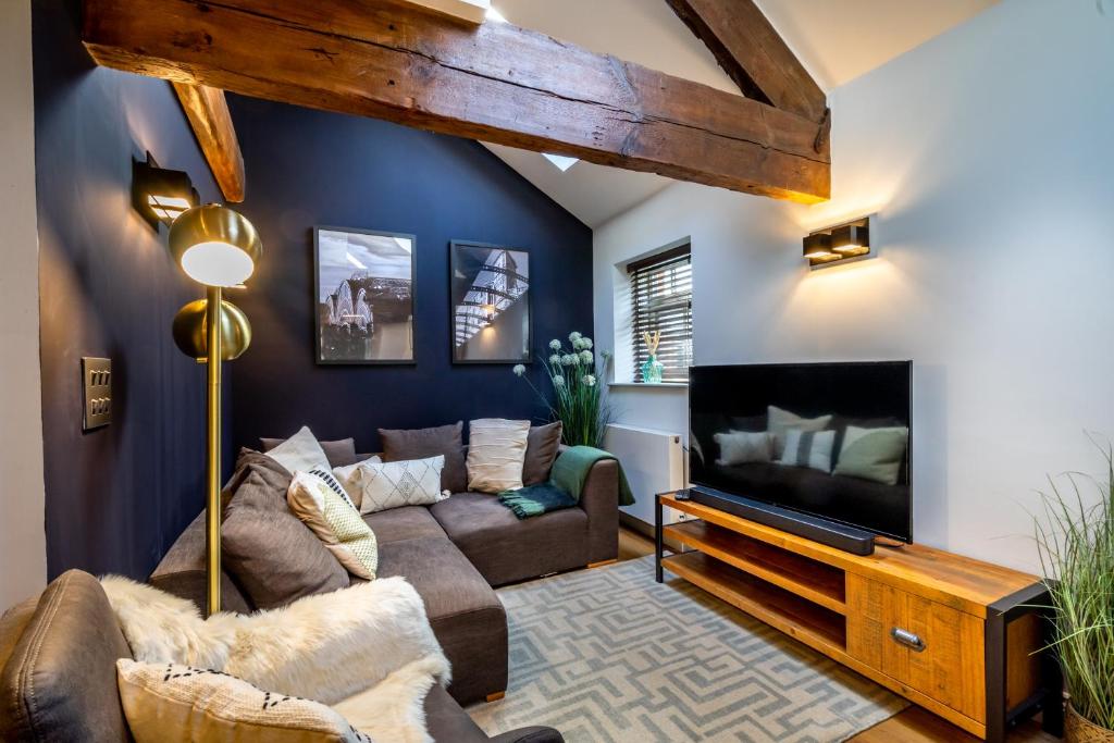 a living room with a couch and a tv at 3 Clementhorpe Maltings in York