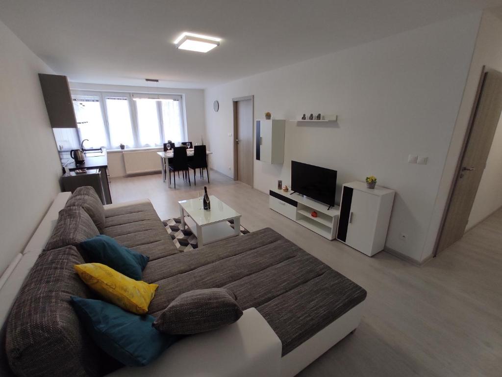 ein Wohnzimmer mit einem Sofa und einem TV in der Unterkunft APARTMÁNY BYTČA in Bytča