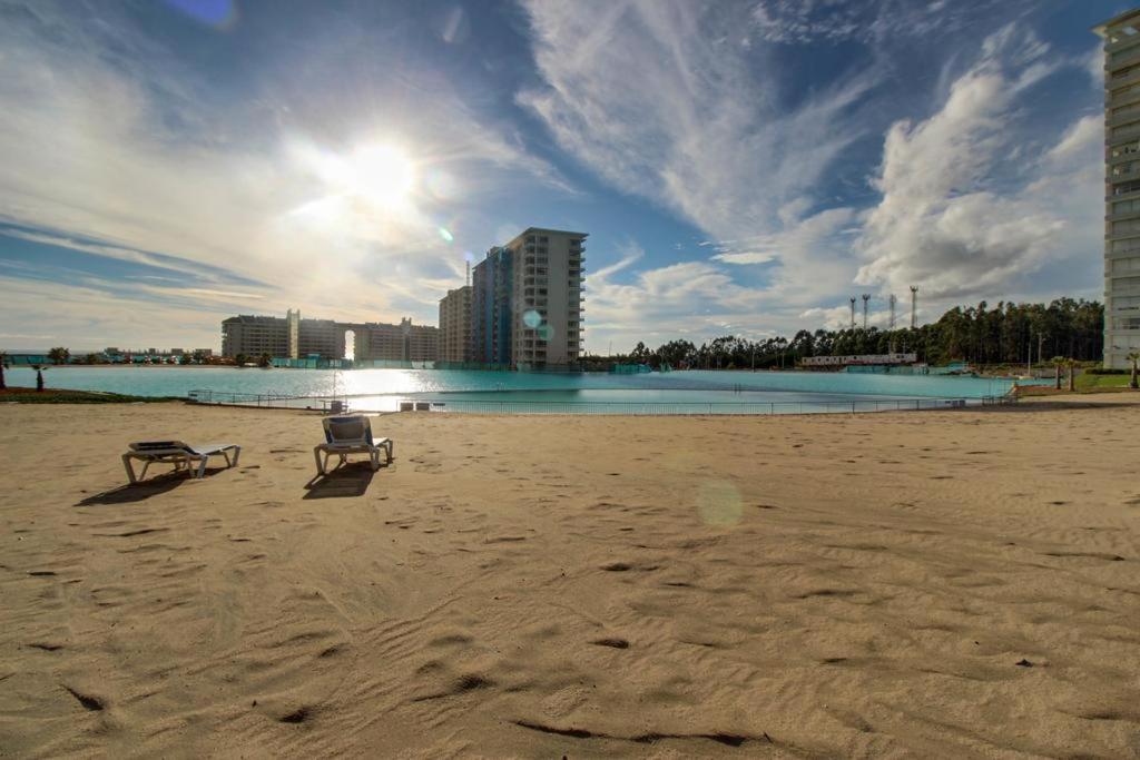 una playa con una silla y un banco en la arena en Laguna Playa Privada, Vista al Mar, en Algarrobo