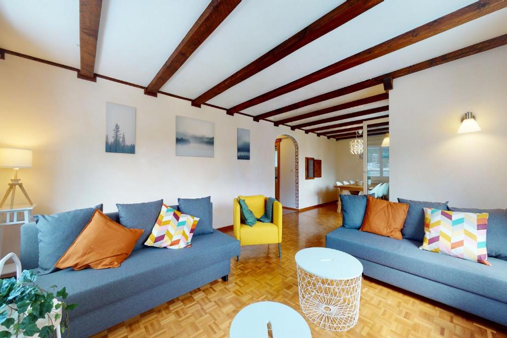 ein Wohnzimmer mit blauen Sofas und einem Tisch in der Unterkunft Apartment Ova Cotschna 301 in St. Moritz