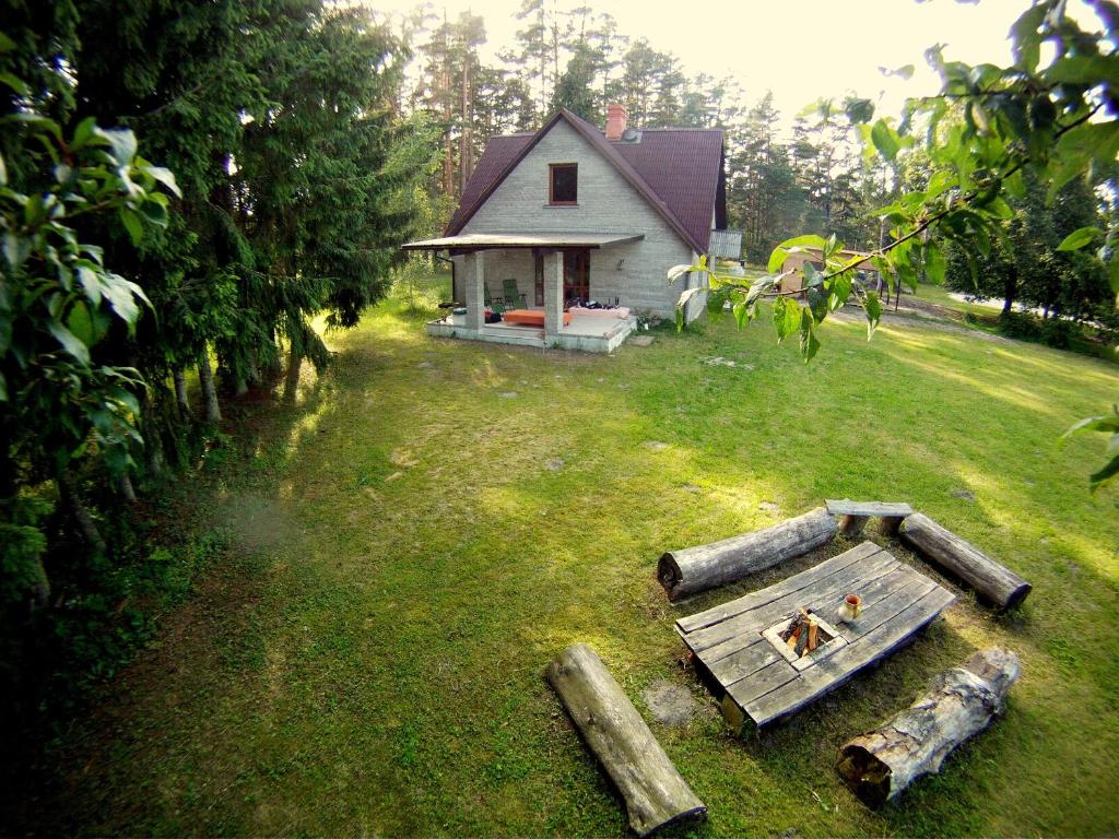 une petite maison avec une table dans la cour dans l'établissement Brīvdienu māja Sauleskrasti, à Mērsrags