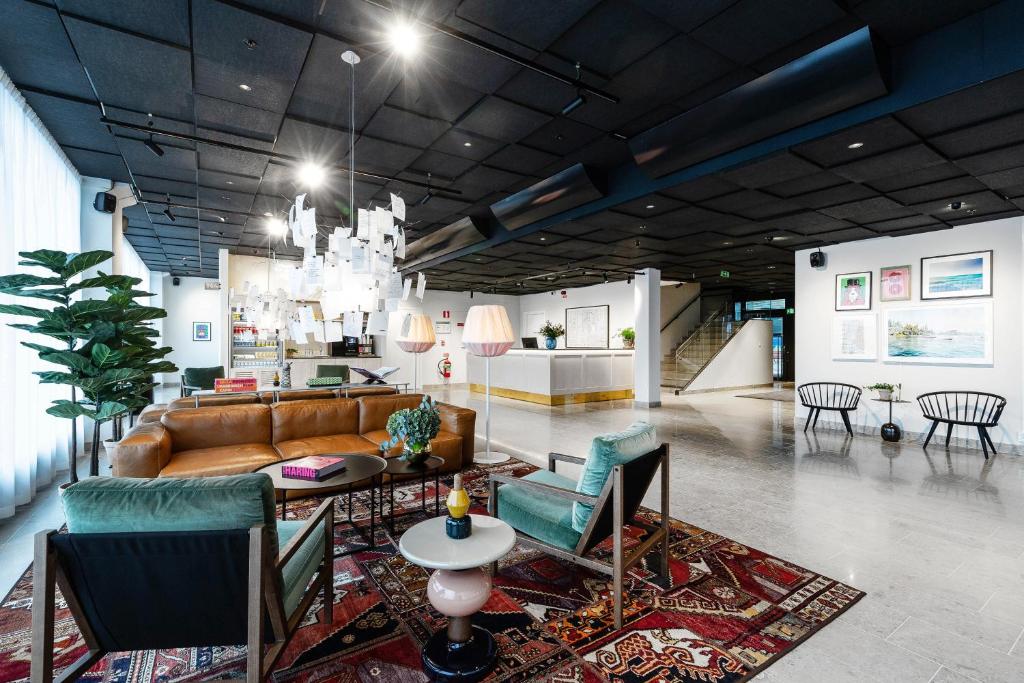 uma sala de estar com um sofá, uma mesa e cadeiras em Biz Apartment Bromma em Estocolmo