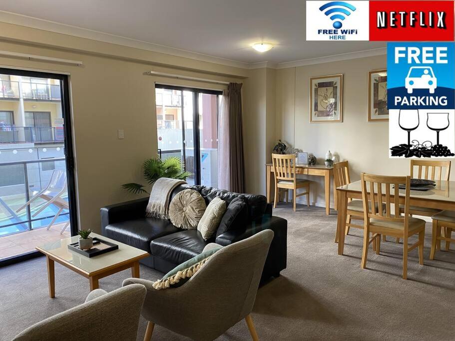a living room with a couch and a dining room at RIVERSIDE CITY VIEW PARKING NETFLIX WIFI WINE FREE in Perth