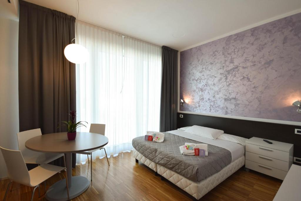 una camera con letto, tavolo e tavolo di Hotel Mantova Residence a Mantova