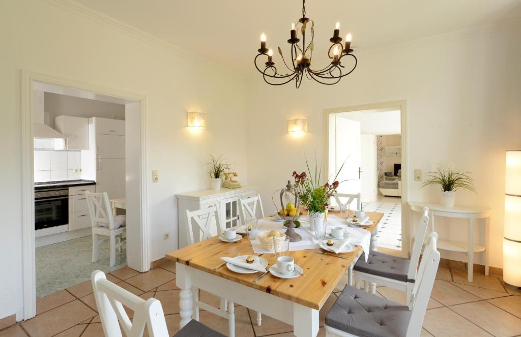 a dining room and kitchen with a table and chairs at Ferienhaus für 8 Personen mit Kamin & Terrasse in Boltenhagen
