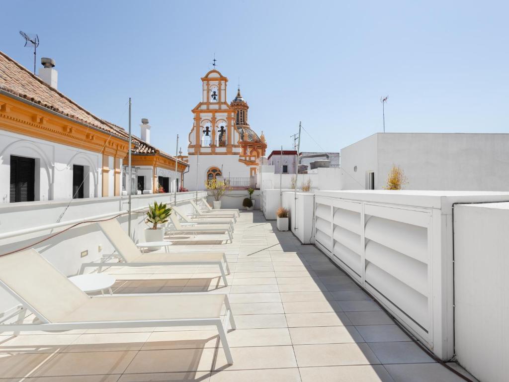 a row of white chairs on the roof of a building at numa I Jondo Apartments in Seville