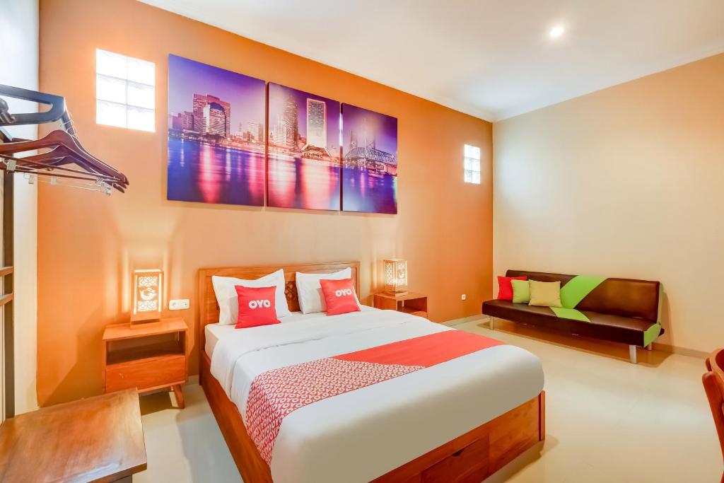 una camera con un grande letto e un divano di OYO 3496 Griya Gayatri Syariah a Yogyakarta