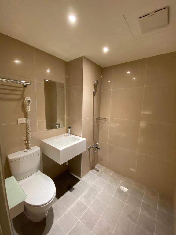 un bagno con un water bianco e un lavandino di Fu Kuang Hotel a Città di Pingtung
