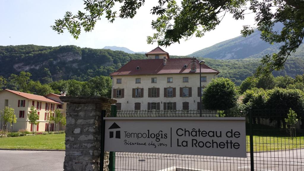 a sign in front of a building with a mountain in the background at Tempologis - Chateau de la Rochette in Fontaine