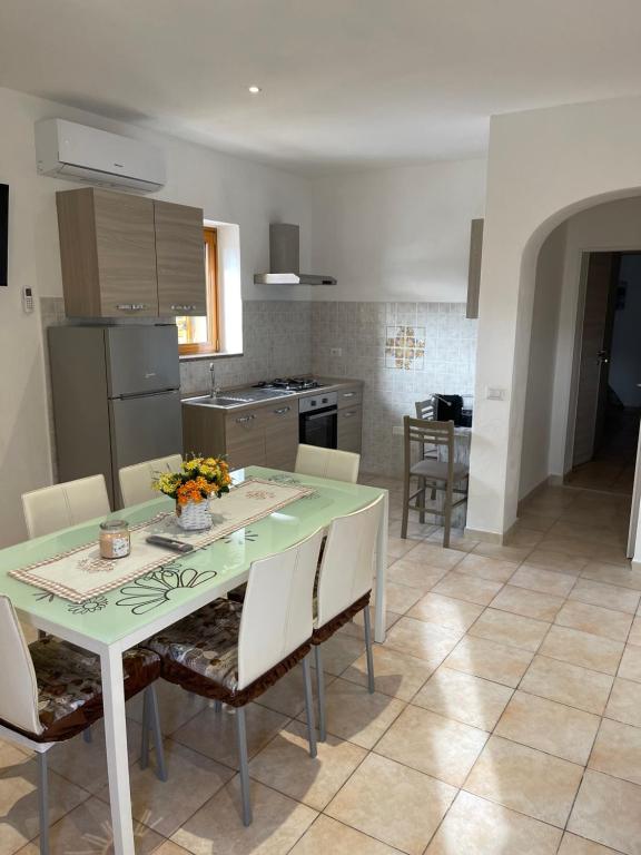 a kitchen and dining room with a table and chairs at Casa Bettina la Maddalena in La Maddalena
