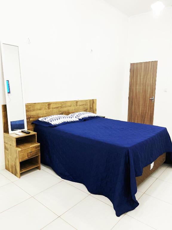 a bedroom with a blue bed and a mirror at Aeroporto House 4 in Macapá