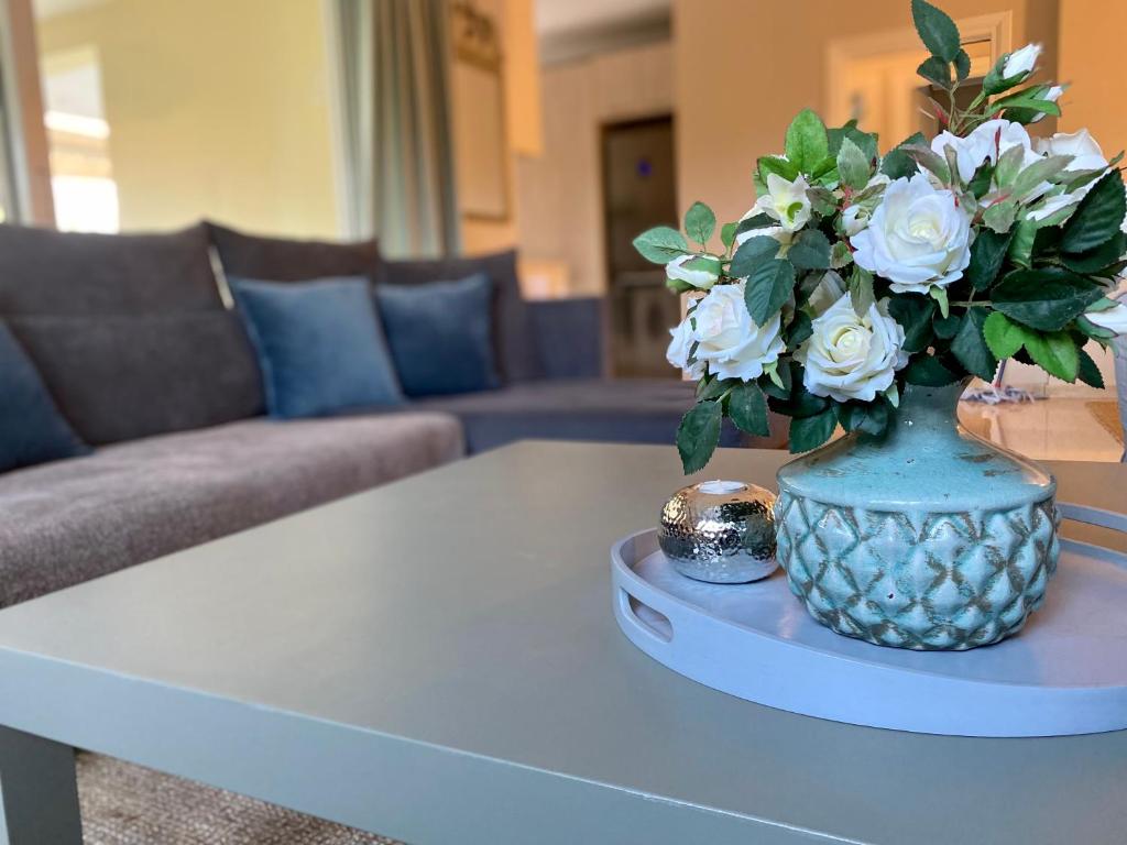 un jarrón azul con flores blancas en una mesa en Marousi Boutique Apartment en Atenas