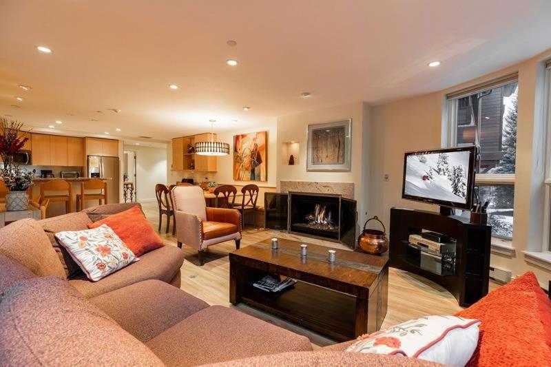 a living room with a couch and a tv at Ski In Ski Out condo with Access to Vail Mountain in Vail