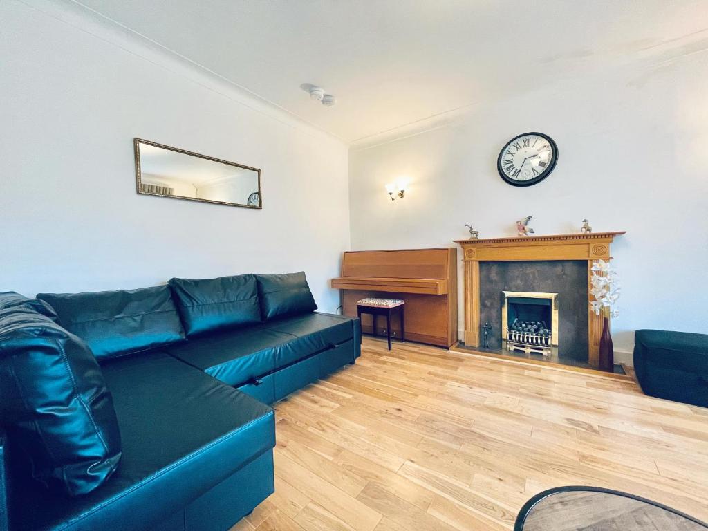 een woonkamer met een bank en een piano bij Millerston House in Glasgow