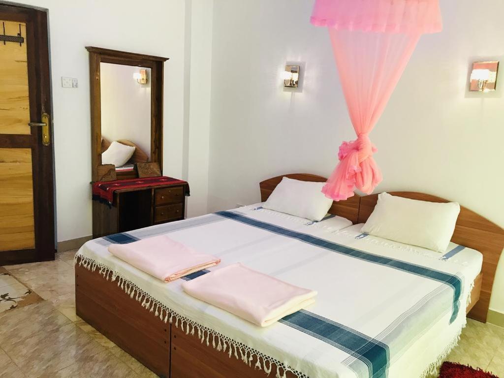 een slaapkamer met een bed met roze handdoeken bij Kandy IVY Banks Holiday Resort in Kandy