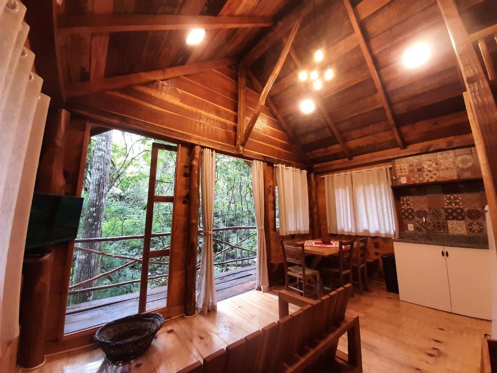 a room with a large window and a dining room at POUSADA CABANA TIO ZEZO in Esteves Júnior
