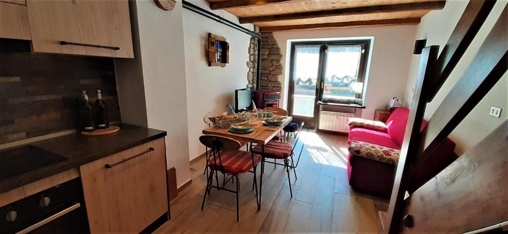 una pequeña cocina con mesa y sillas en una habitación en Maison du Grand Assaly, en La Thuile