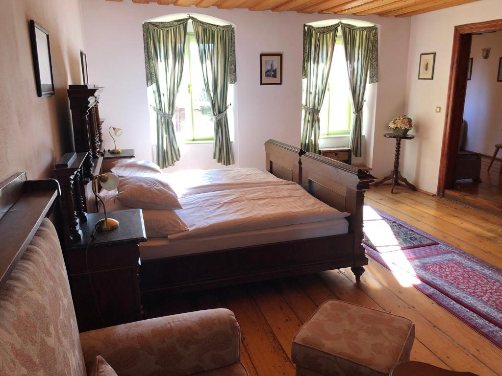 1 dormitorio con 1 cama grande y 2 ventanas en Apartmány pod věží, en Slavonice