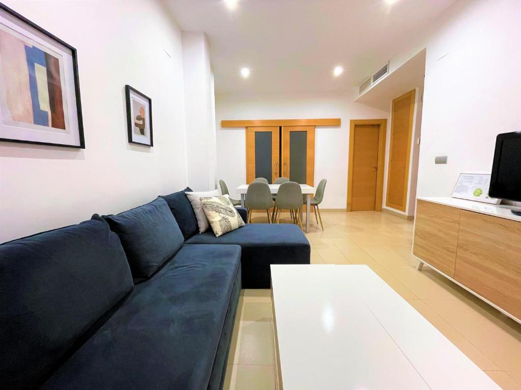 sala de estar con sofá azul y mesa en Be Suites Centro, en Granada
