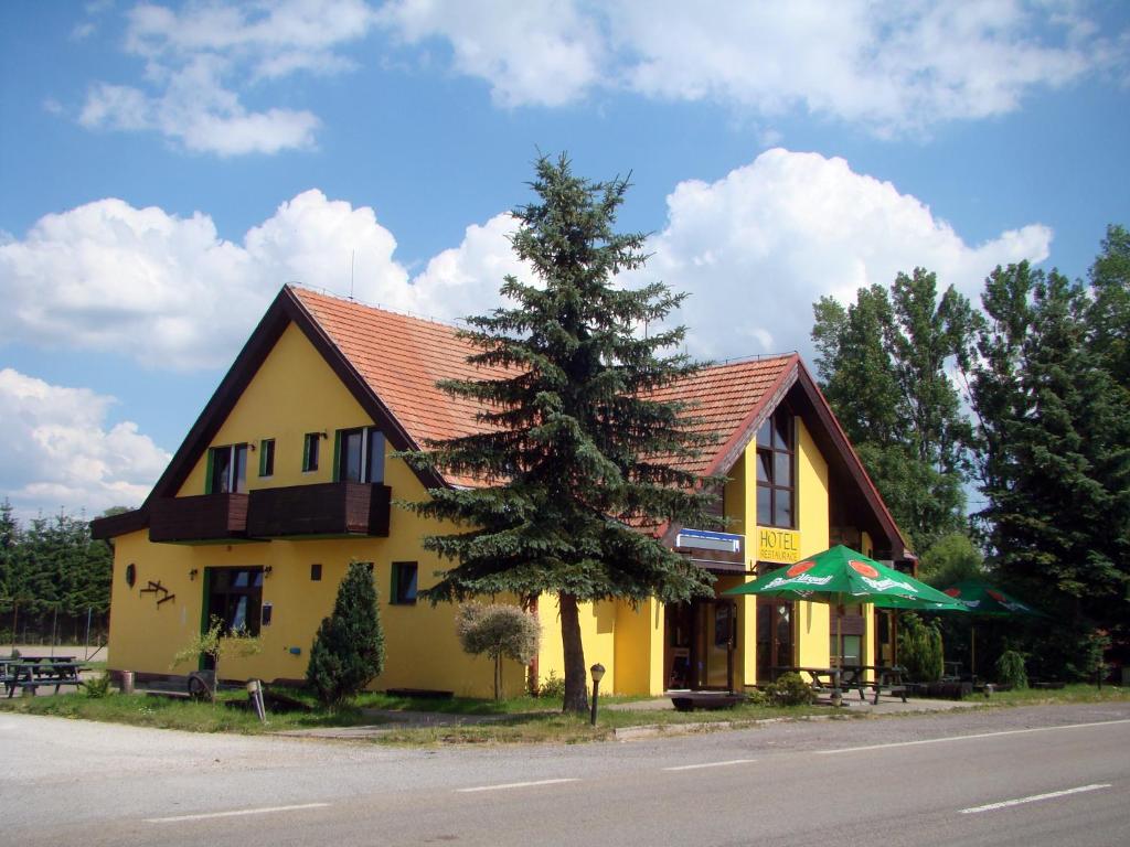 a yellow house with a tree in front of it at Restaurace penzion Rafael in Dlouhá Brtnice