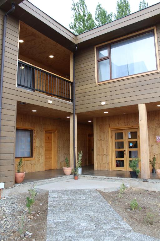 een huis met een veranda en een balkon bij APART HOME COSTANERA in Puerto Tranquilo