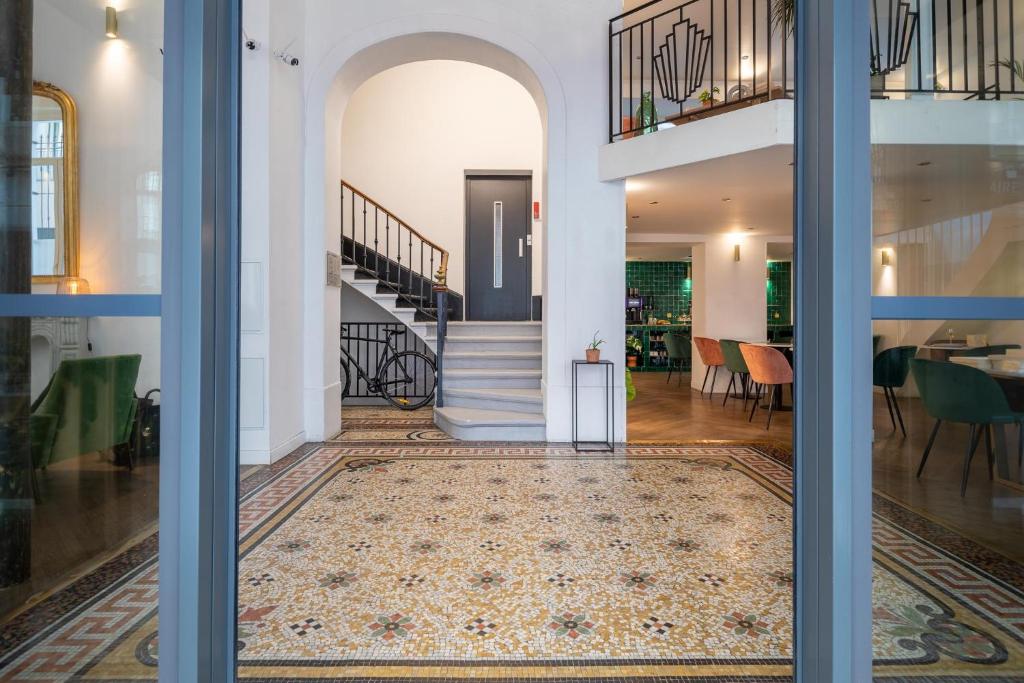 un couloir ouvert avec un escalier dans une maison dans l'établissement 1924 Hôtel, à Grenoble