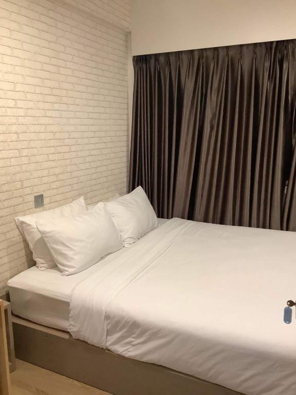 Bett mit weißer Bettwäsche und Kissen in einem Zimmer in der Unterkunft CR.HOTEL in Makkasan