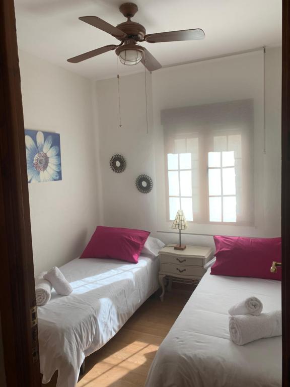 1 dormitorio con 2 camas y ventilador de techo en El balcón de Araceli, en Cercedilla