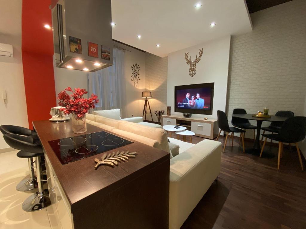 sala de estar con sofá, mesa y TV en Budapest Downtown in Style - Luxury Apartment en Budapest