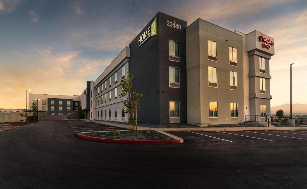 a building with a tree in a parking lot at Home2 Suites By Hilton Riverside March Air Force Base, Ca in Riverside