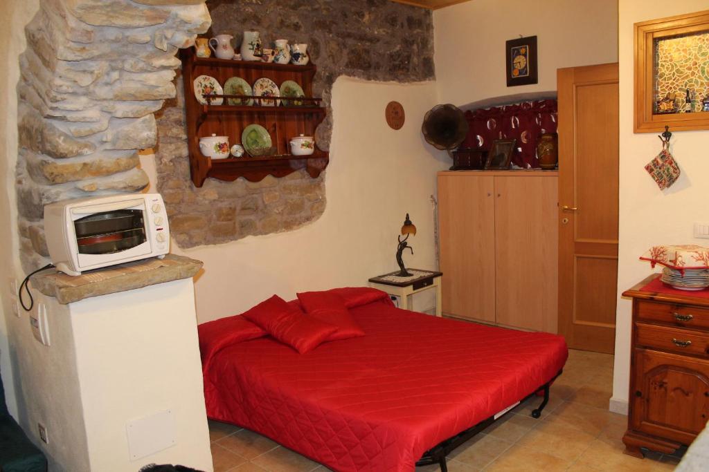 una camera con letto rosso e forno a microonde di Antica Cantina Poesia, San Vito Romano a San Vito Romano
