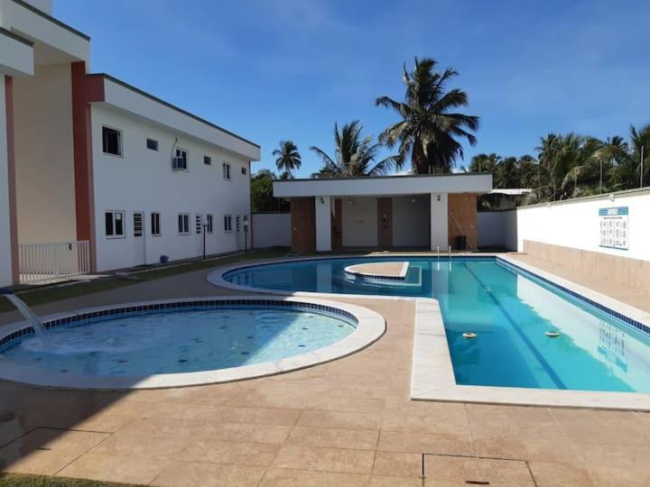 a large swimming pool in front of a building at Maravilhosa casa na praia do Francês in Praia do Frances