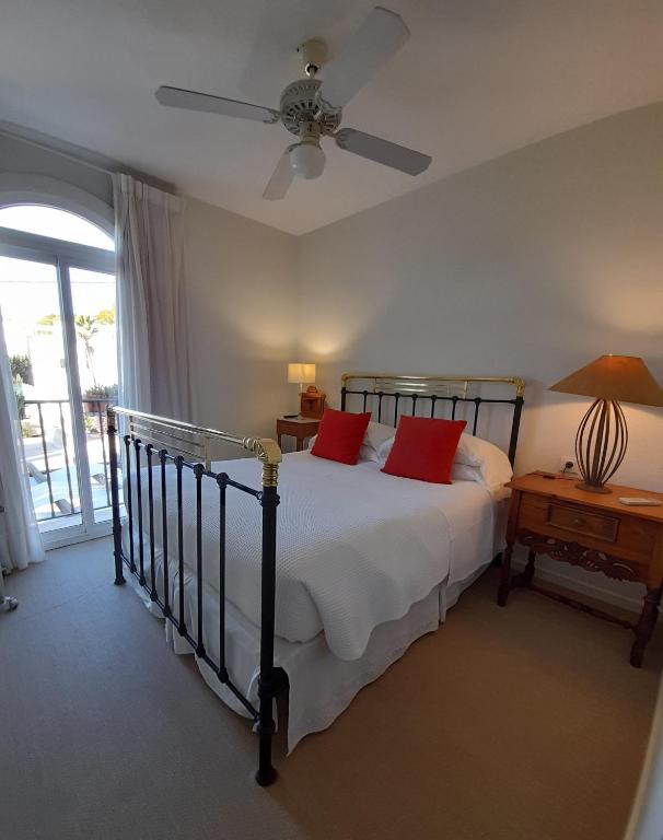 a bedroom with a bed with red pillows on it at miKasa Agua Amarga & SPA in Agua Amarga