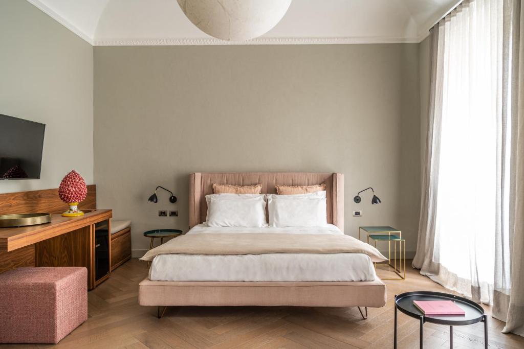 a bedroom with a bed and a tv and a couch at InCanto in Palermo